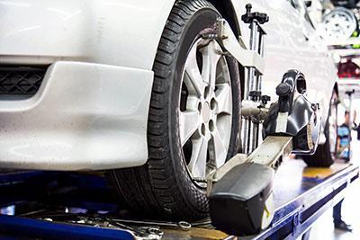 Image of a white car having its alignment adjusted by Active Green + Ross Complete Tire & Auto Centre in Toronto, ON